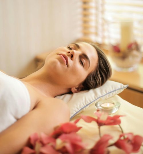 Woman in Wrapped in White Towel Lying on Bed with Eyes Closed