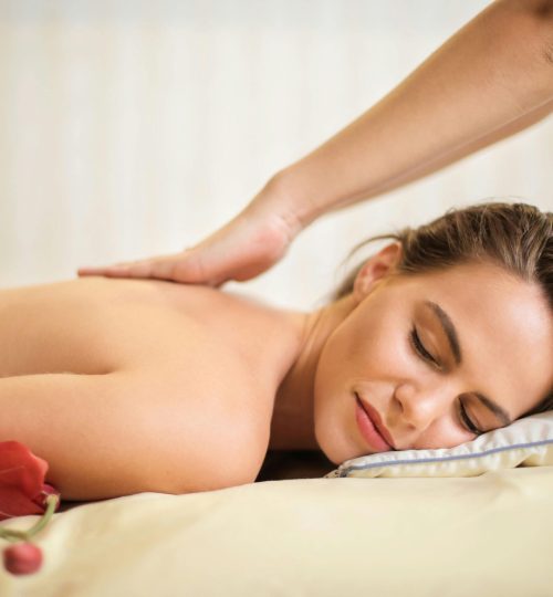 Topless Woman Lying on Bed Getting Massage